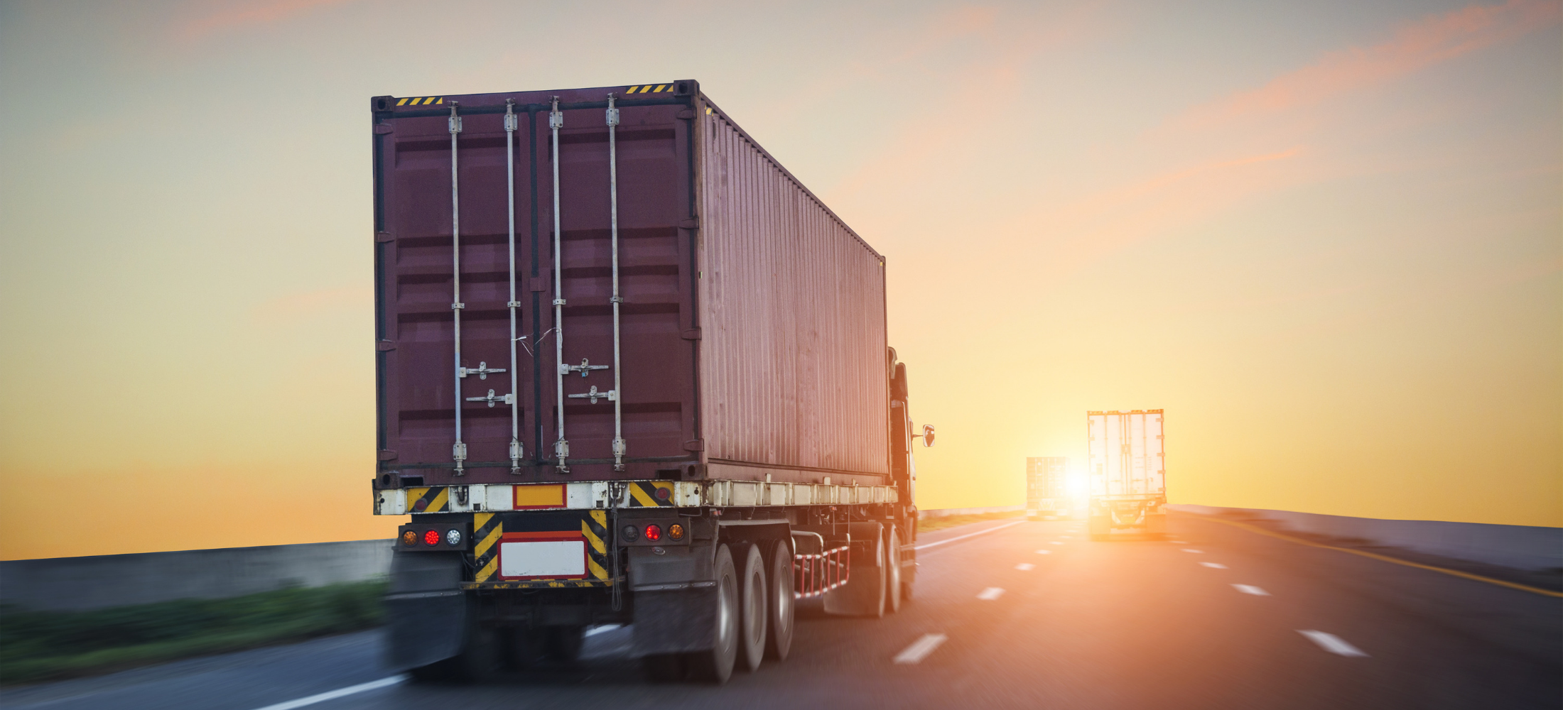 Truck driving off into sunset.