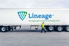 Man in high-vis jacket walking in front of a Lineage truck