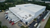 Exterior view of Lineage's College Park cold storage warehouse in Atlanta, GA, with multiple loading docks, parked trucks, and surrounding green landscape, supporting efficient cold chain logistics.